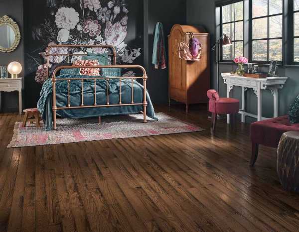 eclectic bedroom with floral accent wall and dark wood floors